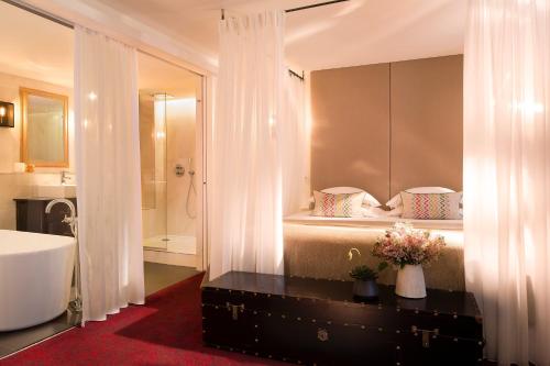 巴黎莫利亚酒店的浴室配有1张带浴缸和水槽的床