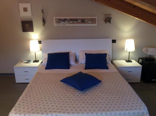 莫内利亚Ca' di Bianca的一间卧室配有一张带蓝色枕头的大床