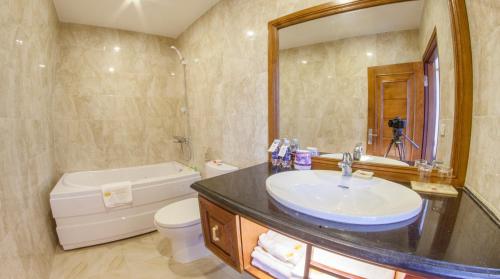 海阳福安2号酒店的一间带水槽、浴缸和卫生间的浴室