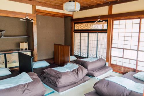 轻井泽高野背包客旅馆的带沙发的客厅,位于带窗户的房间