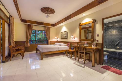 日惹杜达花园酒店的一间卧室配有一张床、一张桌子和一个水槽