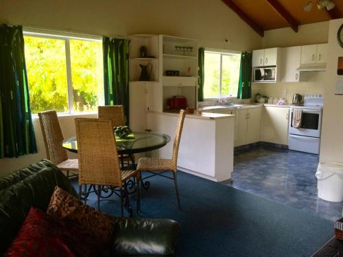 Tuai欧胡卡度假屋的厨房以及带桌椅的起居室。