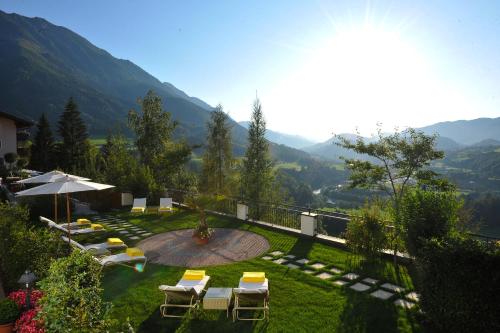 蓬高圣约翰唐纳霍夫阿尔卑斯生活方式酒店的一个带椅子和遮阳伞的花园,