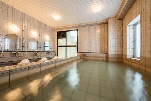 北上市北上绿色饭店　的一个带镜子的浴室内的游泳池
