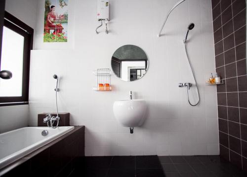 奈汉海滩阿尔夫贝托度假酒店的带浴缸、水槽和镜子的浴室
