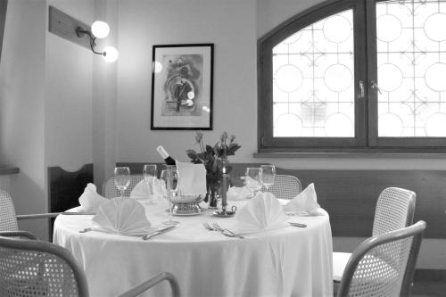 托雷佩利切Hotel Centro的一张桌子、白色的桌布、椅子和窗户