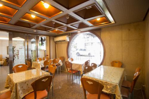 台北凤凰阁温泉饭店的一间带桌椅的用餐室和窗户。