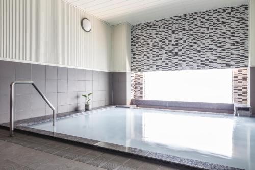仙台仙台远景酒店的带窗户的浴室内的大浴缸