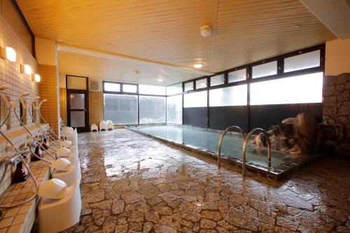 函馆函馆汤之川温泉笑酒店的一间大浴室,在房间内设有一个游泳池