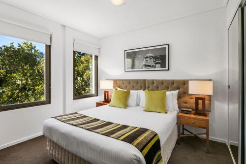 墨尔本魁克斯特奥利蒙酒店的一间卧室设有一张大床和两个窗户。