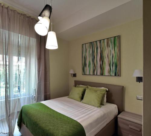 罗马CdR旅馆的一间卧室配有一张带绿色床单的床和一扇窗户。