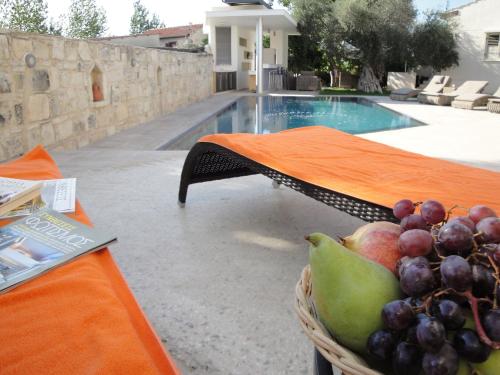 AmargetiKaizer Agrotourism的游泳池畔桌子上的一篮水果