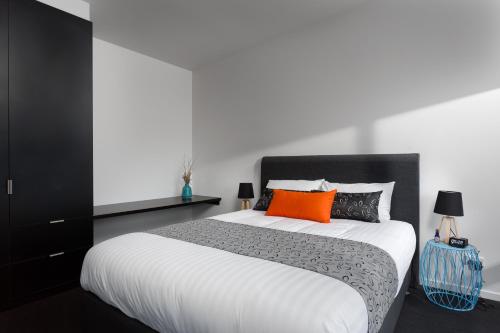 Ventnor比姆巴丁菲利普岛农家乐的一间卧室配有一张带橙色和黑色枕头的大床