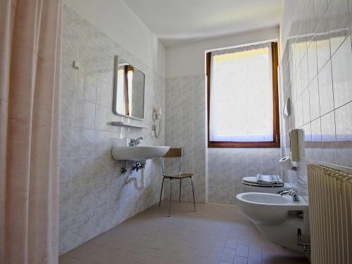 阿维奥Albergo Alpino da Tullio的白色的浴室设有水槽和卫生间。