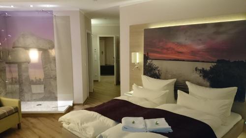 安格尔明德维斯弗莱尔酒店的卧室配有一张大床,墙上挂有绘画作品