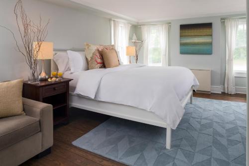 Shelter Island Heights谢尔特岛旅馆的卧室配有一张白色的大床和一张沙发。