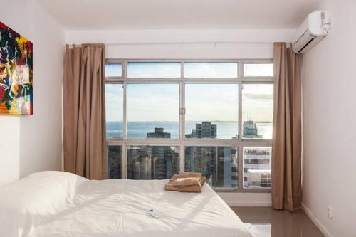 萨尔瓦多Luxury Surround Sea View Apartment的一间卧室设有一张床和一个大窗户