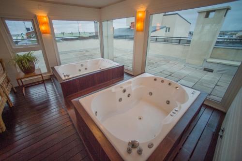 里奥加耶戈斯Hotel Patagonia的大型浴室设有两个浴缸和大窗户。