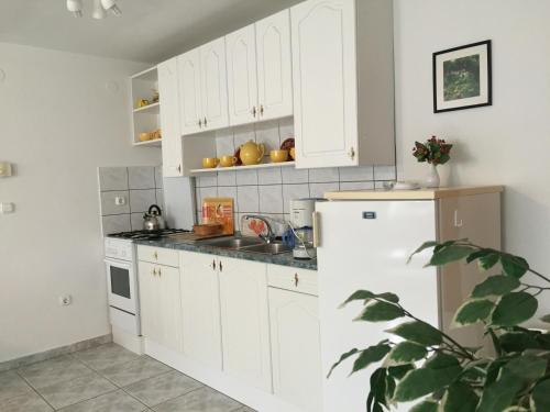 巴拉通尤洛克Frankie Holiday Apartment II.的厨房配有白色橱柜和白色冰箱。
