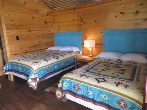 StockdaleAll Tucked Inn Cabins的木墙客房的两张床
