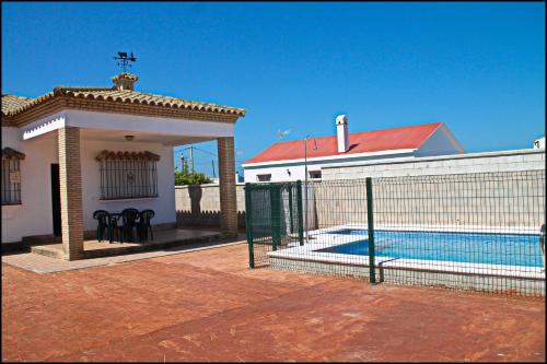 科尼尔-德拉弗龙特拉Chalet Arroyo Majadales 107的一座带围栏和游泳池的房子