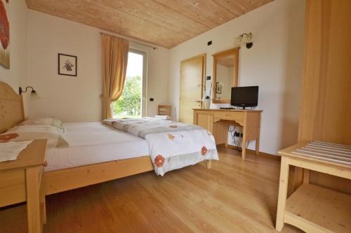 特伦托罗坎达农家乐的一间卧室配有一张床、一张书桌和一台电视