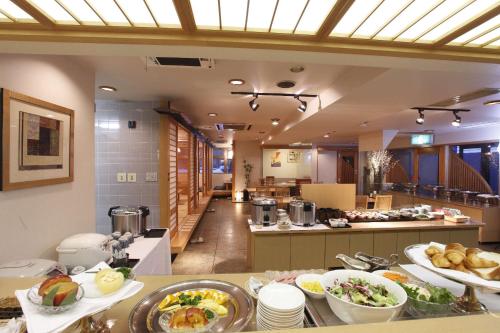 弘前市弘前广场酒店 的厨房里有很多盘子的食物放在桌子上