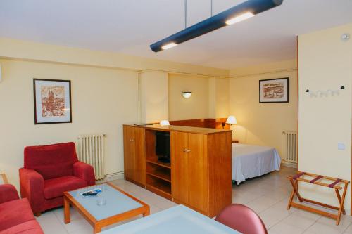 巴塞罗那伯特伦公寓酒店的客厅配有红色椅子和一张床