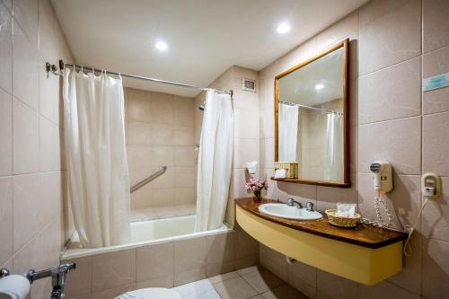 Macuto奥莱加勒比酒店的一间带水槽、淋浴和镜子的浴室