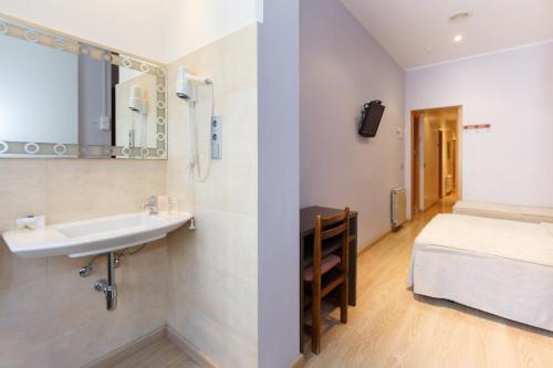 巴塞罗那Ciudad Condal Hostal - Paseo de Gracia的一间带水槽的浴室和一张位于客房内的床