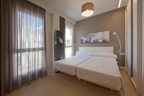 维多利亚-加斯特伊兹伊伦纳斯公寓的一间卧室设有一张大床和一个大窗户