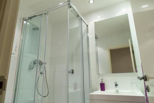 巴塞罗那康德古尔公寓式酒店的带淋浴、盥洗盆和镜子的浴室