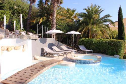 卡西斯皇家小别墅酒店的庭院内带椅子和遮阳伞的游泳池