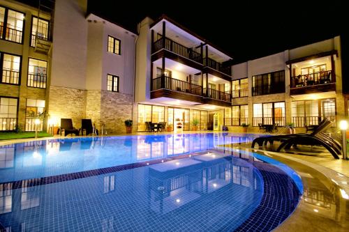 帕莫卡莱维纳斯套房酒店 的一座大楼前的大型游泳池