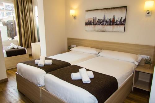 巴塞罗那巴塞罗那漫游旅馆的酒店客房,配有两张带毛巾的床