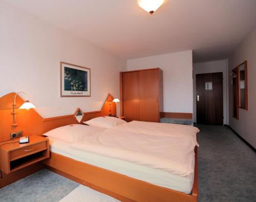 霍夫盖斯马尔祖姆滕坊酒店的一间卧室配有一张大床和木制床头板