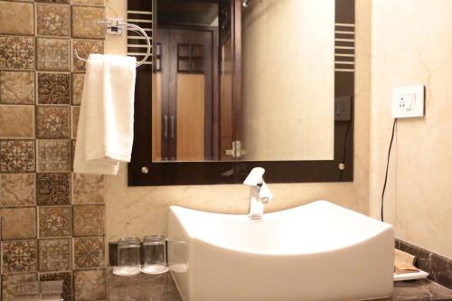 瓦拉纳西兰德马克酒店的一间带水槽和镜子的浴室