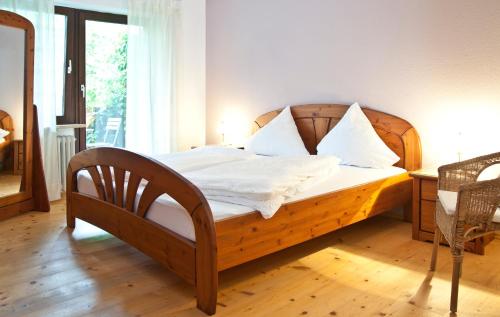 NennslingenFerienwohnungen Grimm的一间卧室配有一张带白色床单和枕头的木制床。