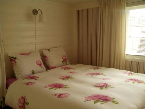 登海尔德Apartment Boven Jan 572的卧室里一张带粉红色花的床铺