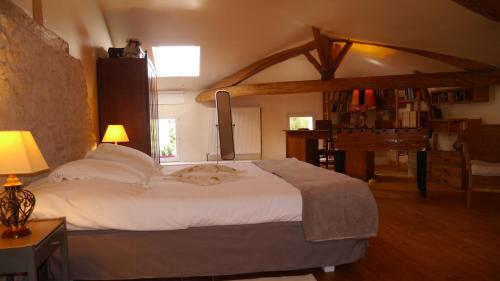 洛特河畔的维伦纽夫Gîte du Corupsis的卧室配有白色大床和钢琴