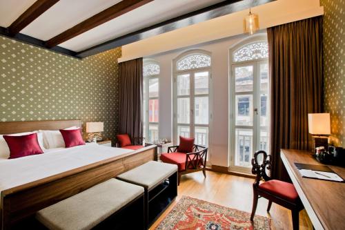 新加坡The Sultan的配有一张床和一张书桌的酒店客房