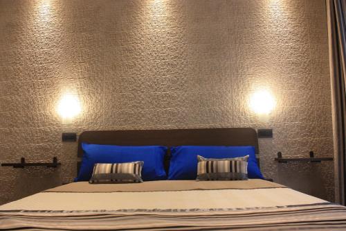 阿尔盖罗Terrazzi in Fiore的一张带蓝色床头板的床和两个枕头