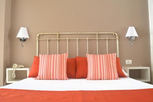拉克鲁斯RF阿斯托利亚酒店 - 仅限成年人的一间卧室配有带橙色和白色枕头的床