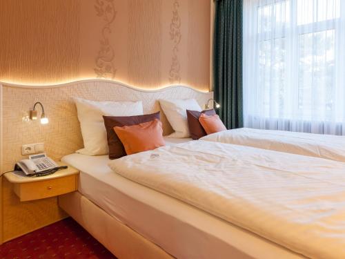 蒂门多弗施特兰德Park-Hotel的酒店客房带两张床和电话