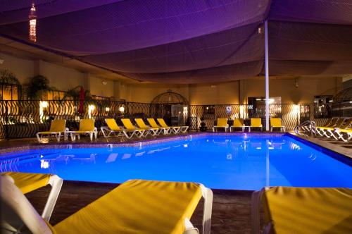 拉斯维加斯赛马俱乐部套房酒店的酒店设有一个大型游泳池,游泳池内摆放着黄色的椅子