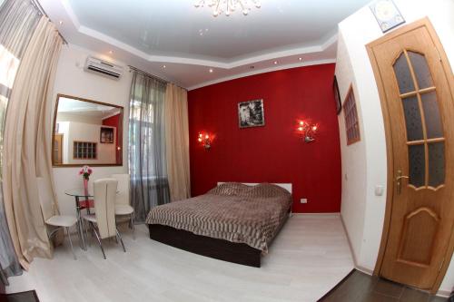 敖德萨Apartments De-Ribas的红色卧室配有床和桌子