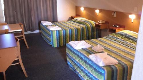 英厄姆赫伯特谷汽车旅馆的酒店客房设有两张床和一张桌子。