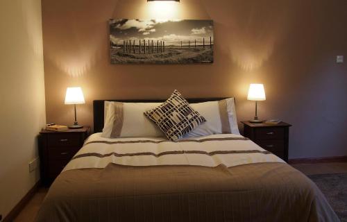 MilfieldPantile Lodge的一间卧室配有一张大床和两盏灯