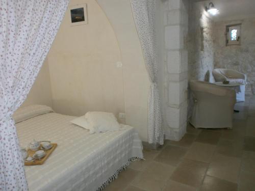 奥斯图尼Trullo Villa Giuliana con giardino Posizione panoramica Free wifi的一间卧室配有一张床、一个浴缸和一个水槽
