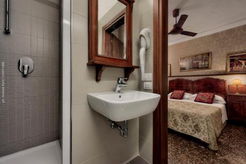 威尼斯加勒里亚酒店的一间带水槽的浴室和一间带一张床的卧室